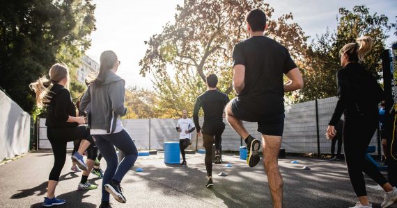 un groupe de jeunes fait du fitness en extérieur avec un instructeur