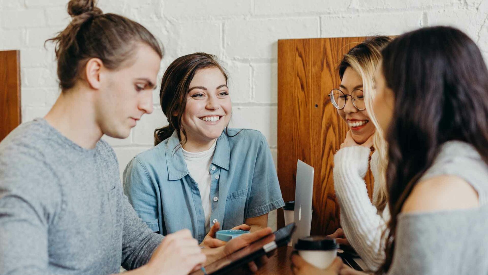 un groupe de jeunes travaillent ensembles autour d'une table en intérieur