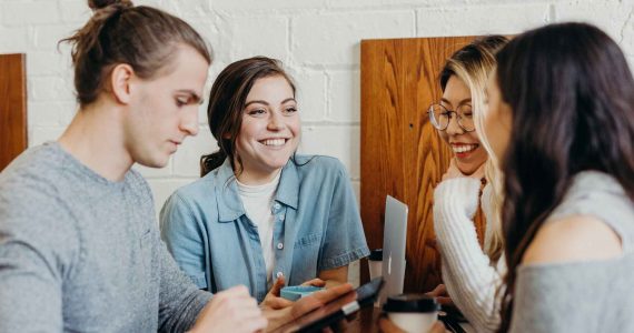 un groupe de jeunes travaillent ensembles autour d'une table en intérieur